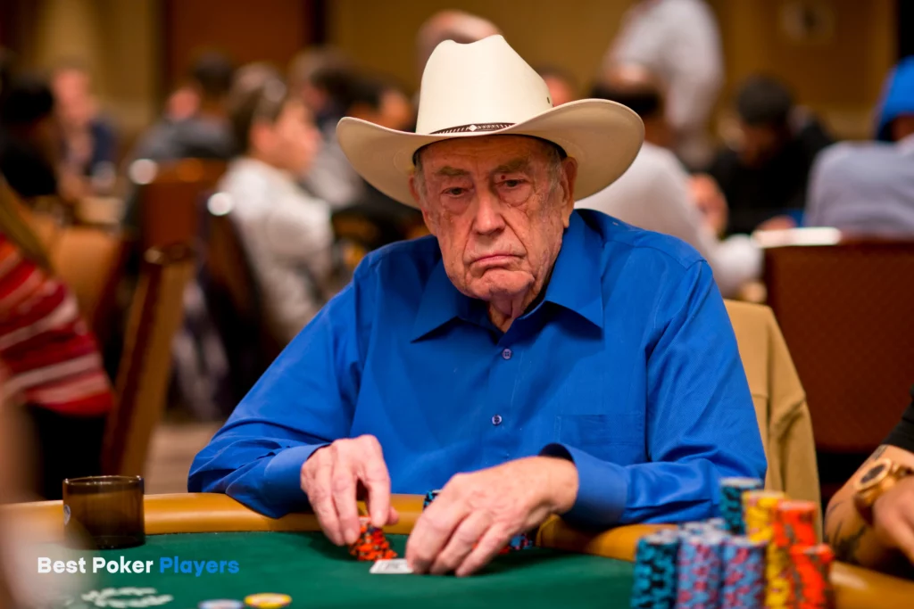 Doyle Brunson playing poker at table wearing cowboy hat with chips stacked